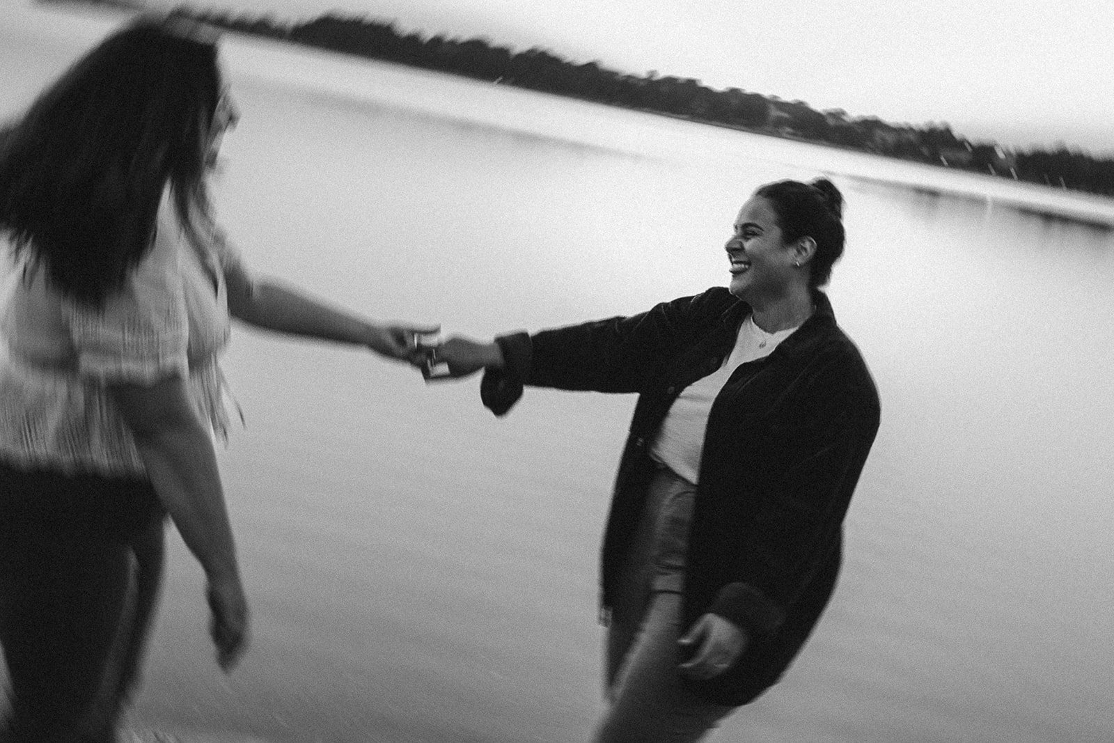 A beautiful couple hold hands by the sea during their Castle island engagement photos 