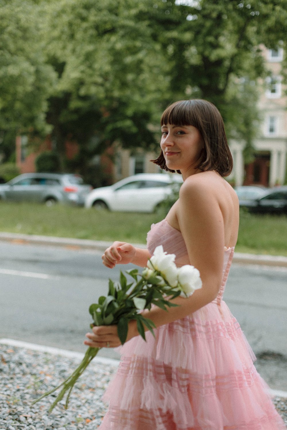 Stunning young lady poses in pink beside the Boston street