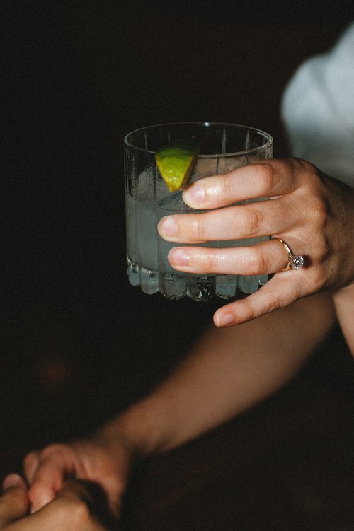 A couple sip cocktails together during their Boston engagement shoot 