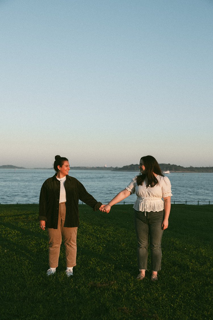 A beautiful couple hold hands by the sea during their Castle island engagement photos 