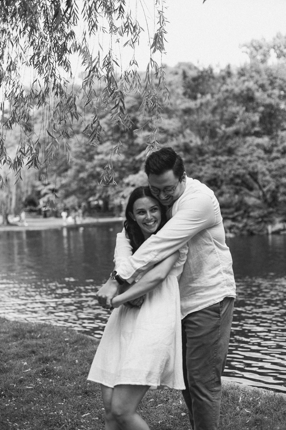 Stunning couple share a romantic pose during their waterside engagement photoshoot