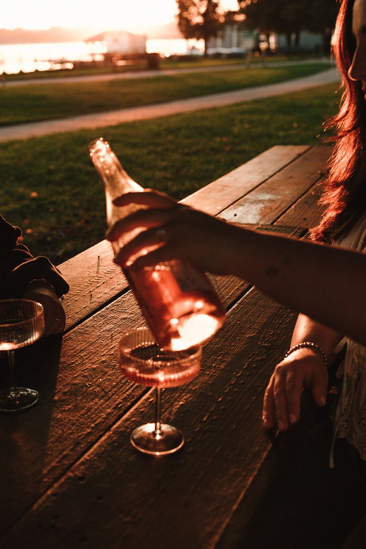 A beautiful couple share some wine by the sea during their Castle Island engagement photos