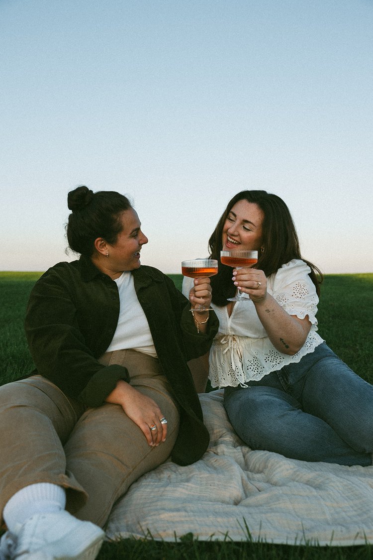 A beautiful couple share some wine by the sea during their Castle Island engagement photos