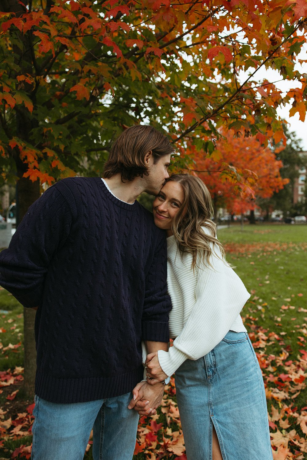 Stunning couple pose together under a colorful tree during their Boston engagement photos