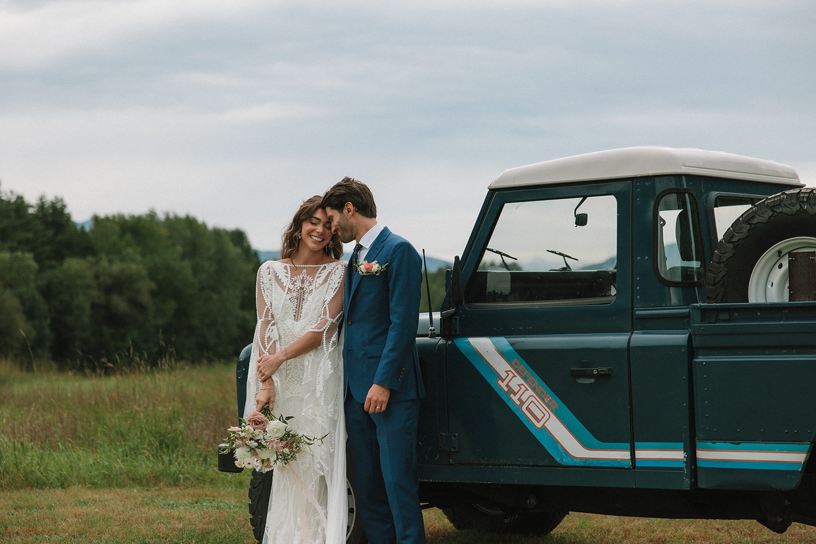 Beautiful bride and groom pose in front a classic truck