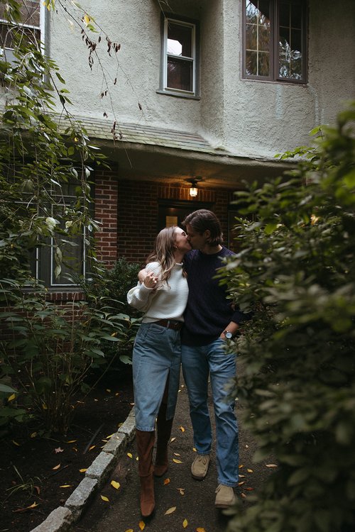 Stunning couple pose together in front of a beautiful New England home during their Boston engagement photos