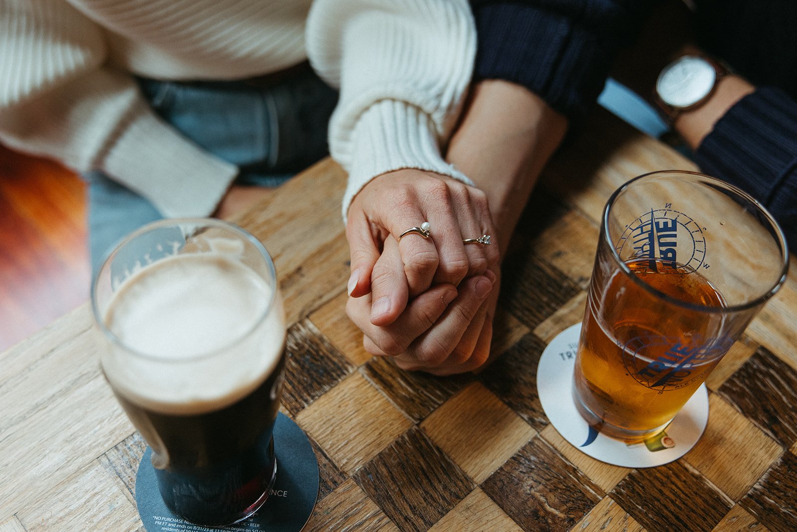 creative photo of couple at pub in cambridge with their engagement ring