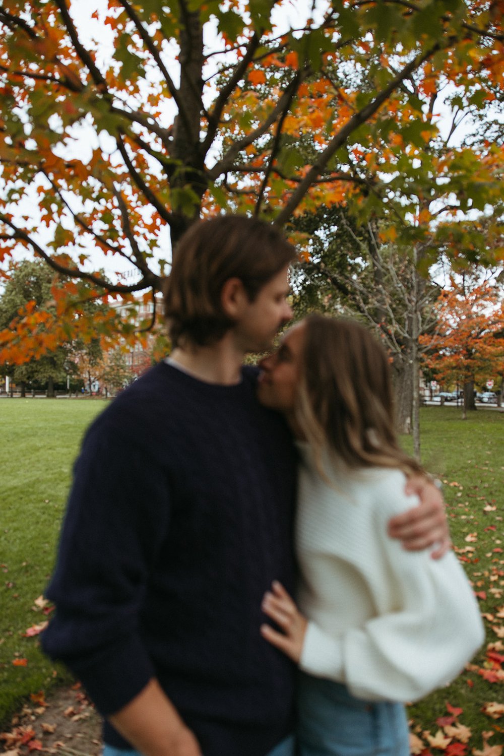 Stunning couple pose together under a colorful tree during their Boston engagement photos