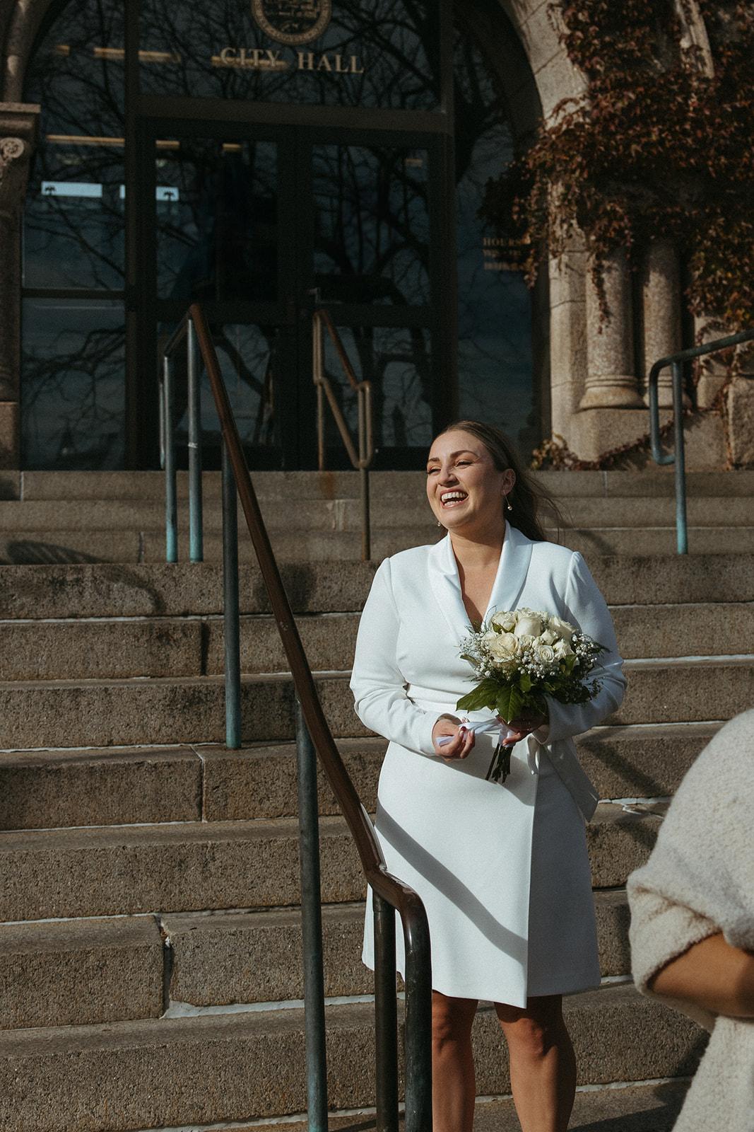 stunning bride poses outside city hall after their Massachusetts elopement 