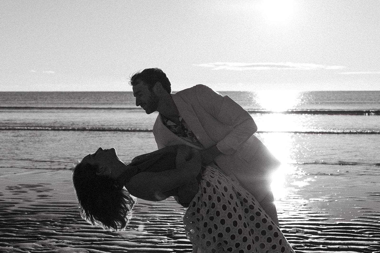 beautiful couple pose on the beach together 