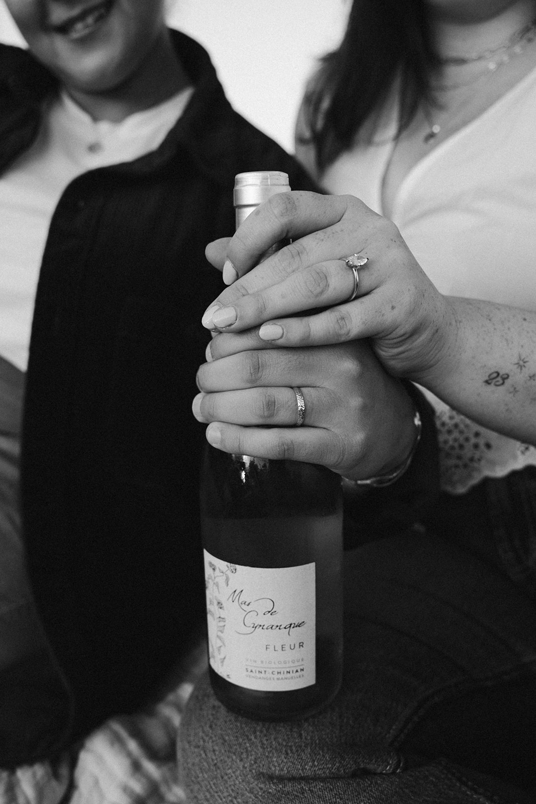 Couple sit together on a picnic sharing wine and laughs captured by their boston wedding photographer