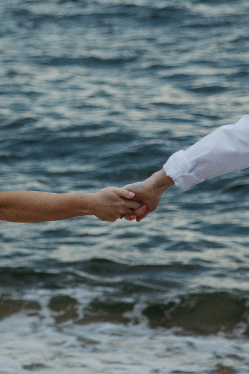 couple holding hands on plum island beach