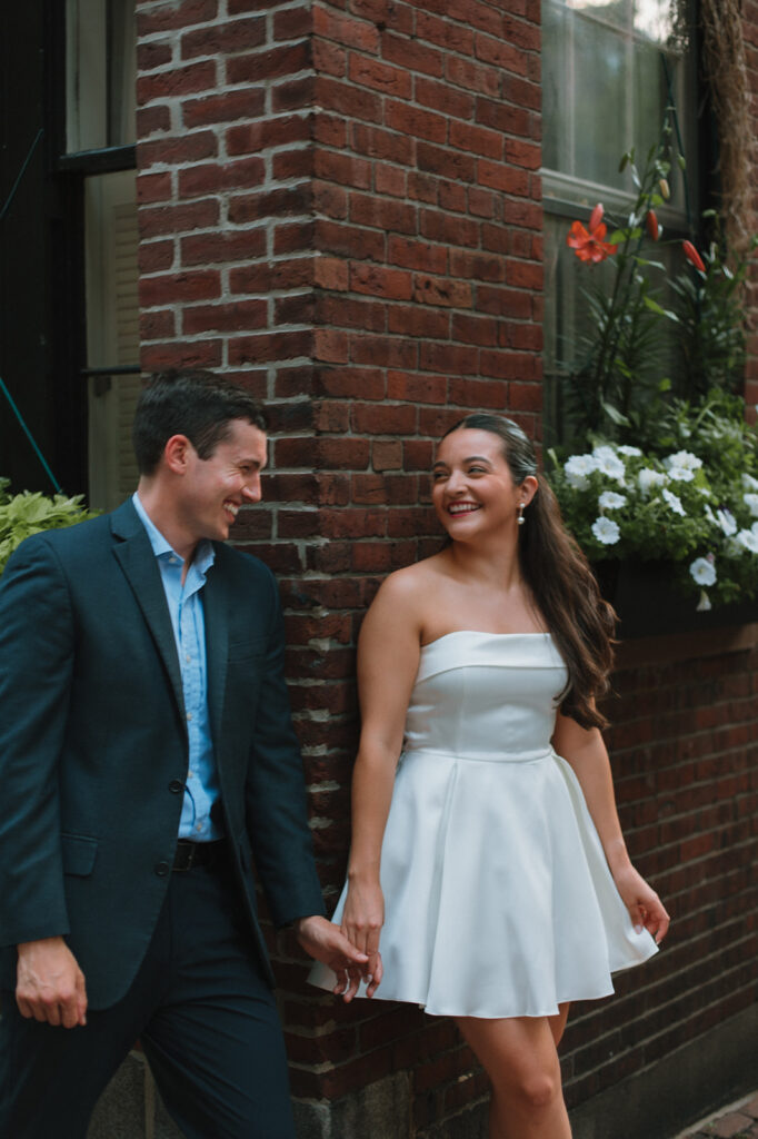 couple laughs during engagement photos in beacon hill in boston