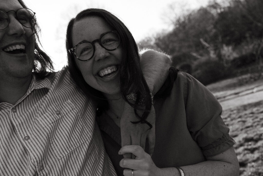 Couple laughs during candid engagement session at Arnold Arboretum in Boston