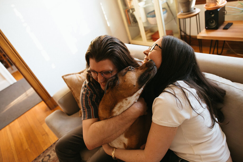 Couple cuddles dog and laughs during their unique documentary style engagement session at home in Boston