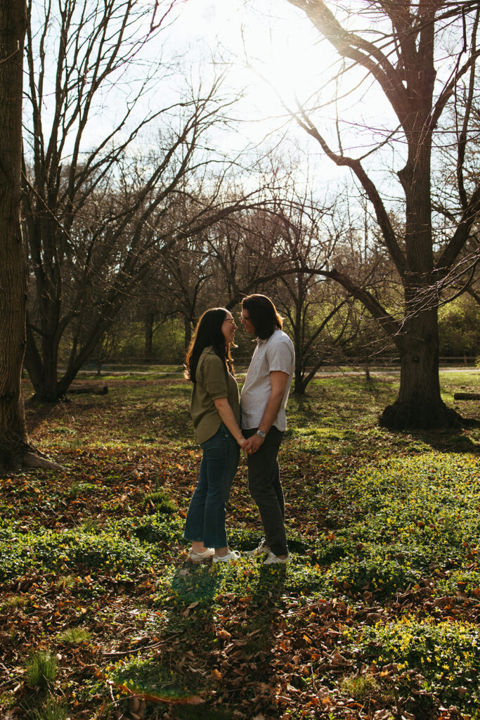 couple poses for engagement photos during sunset in Arnold Arboretum at Harvard University