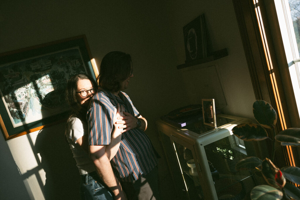 couple listens to records in their apartment during moody and casual engagement session