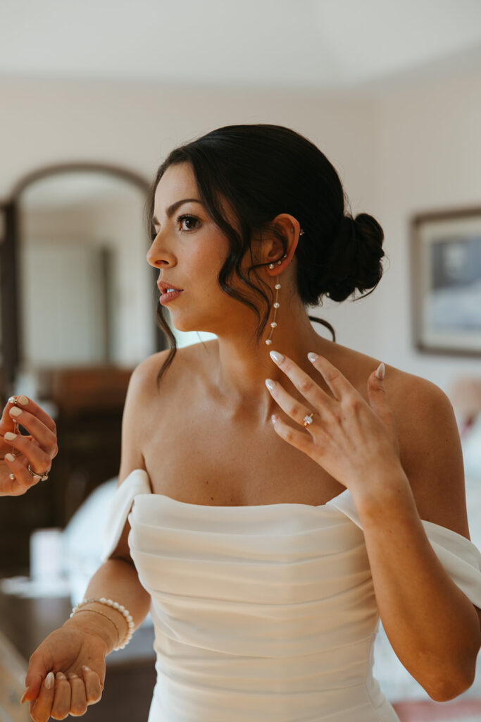 Bride Putting on Earrings Before Wedding Ceremony at Misslewood in Beverly Massachusetts