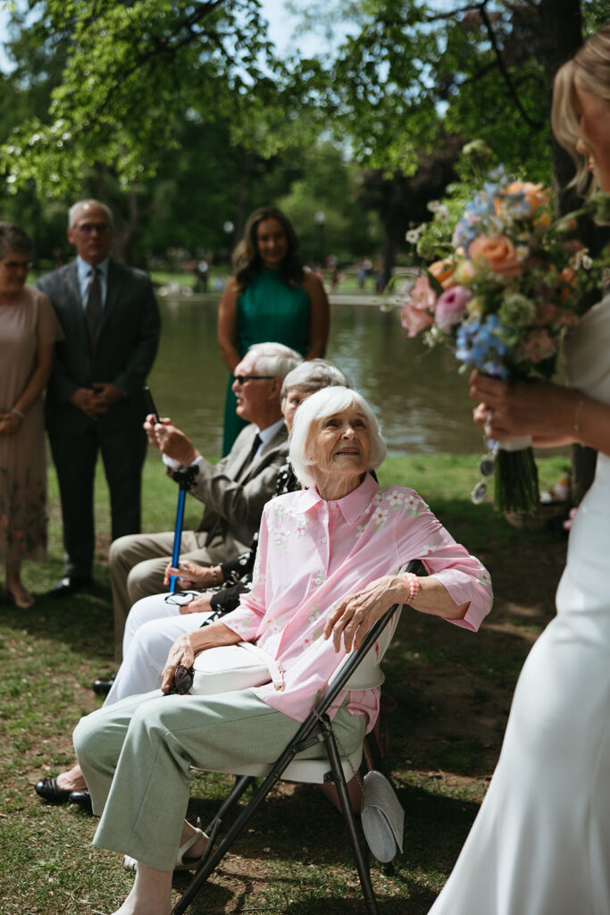 Grandmother watches granddaughter walk down the aisle during Boston Common wedding ceremony