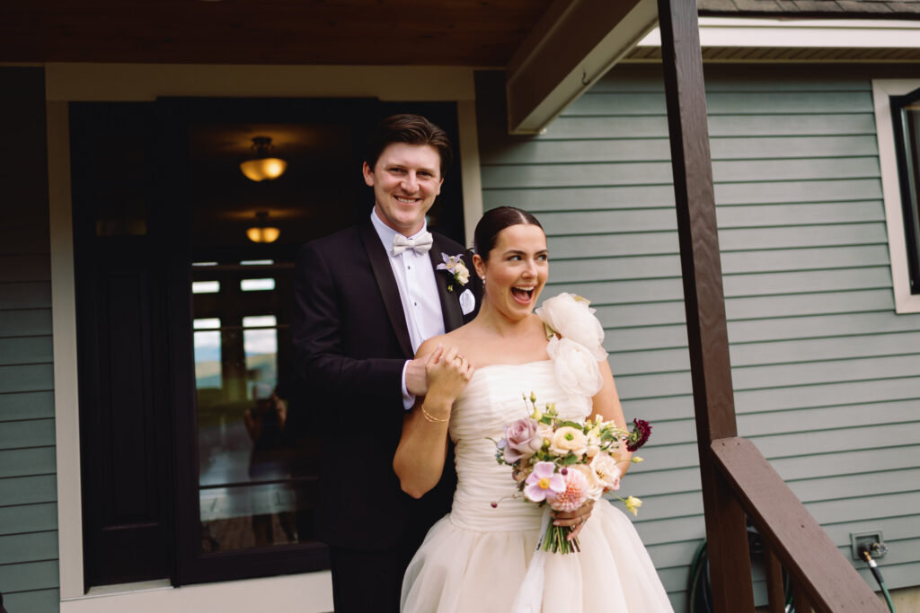 candid wedding photo of bride and groom laughing and holding hands