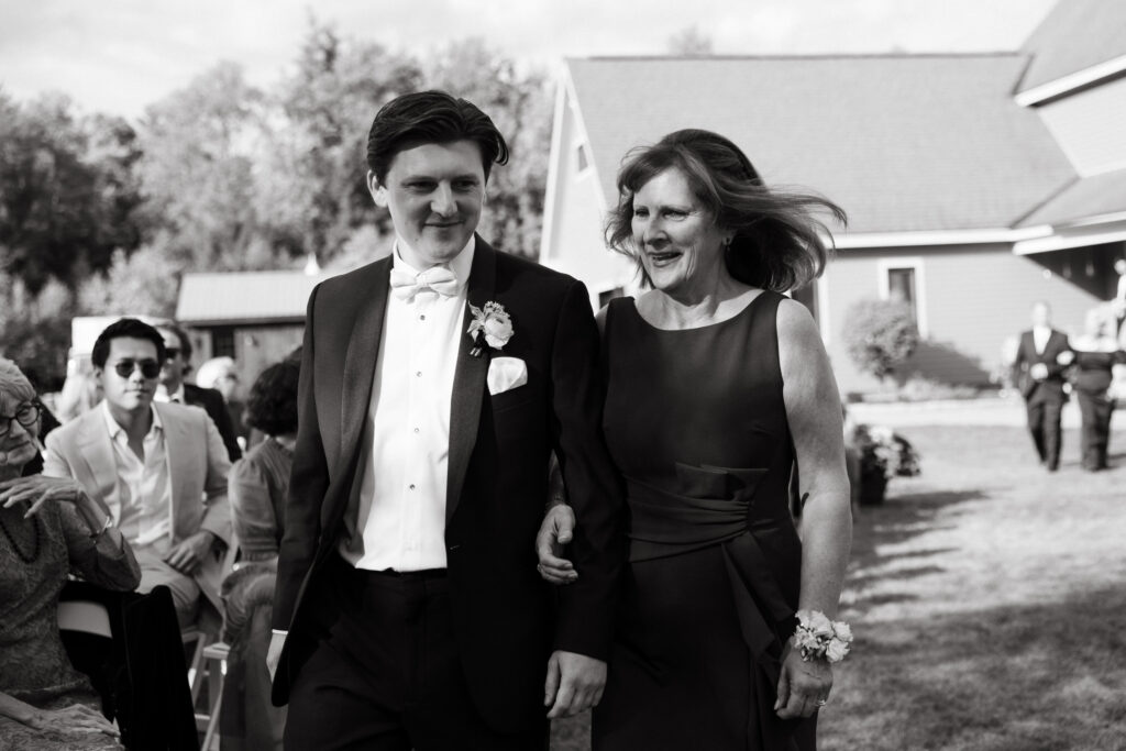 groom walks down the aisle with mom