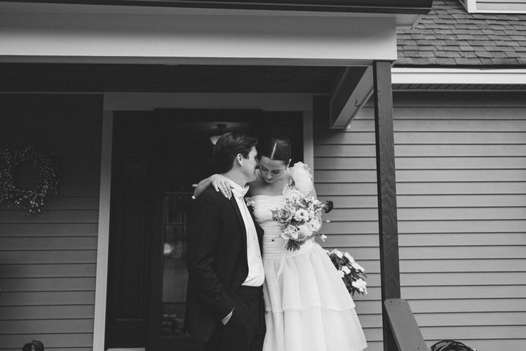 film-inspired candid wedding photo of bride and groom on porch at their backyard wedding