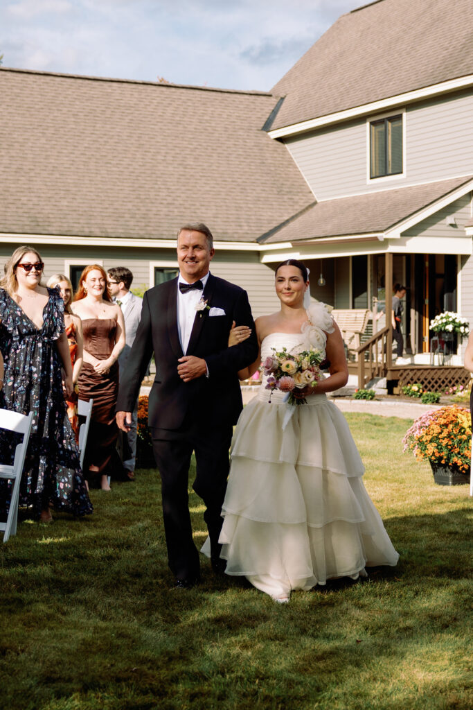 bride walks down the aisle with her father in a vintage wedding gown from NYC