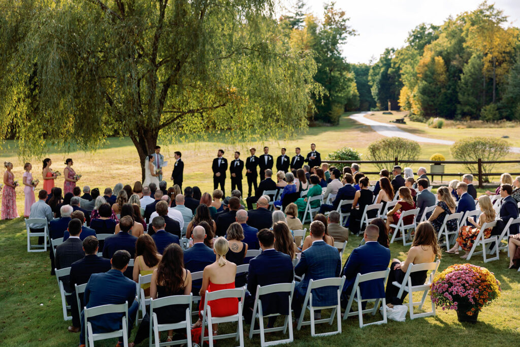 intimate wedding ceremony in front of willow tree in the fall