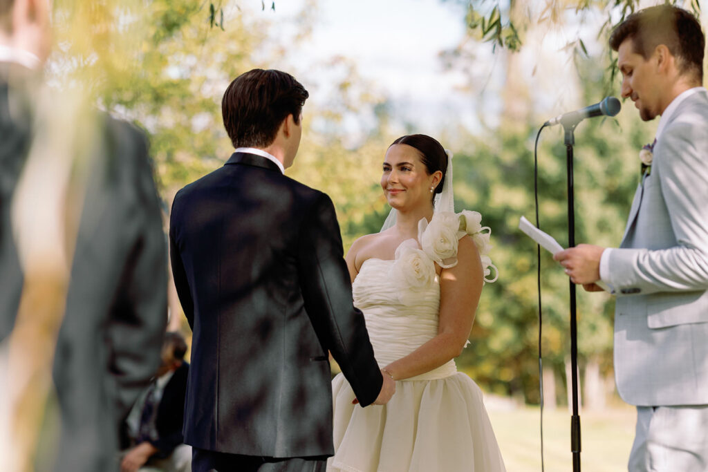 bride and groom hold hands during wedding ceremony