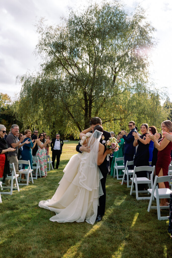 bride and groom kiss down the aisle during intimate fall wedding ceremony