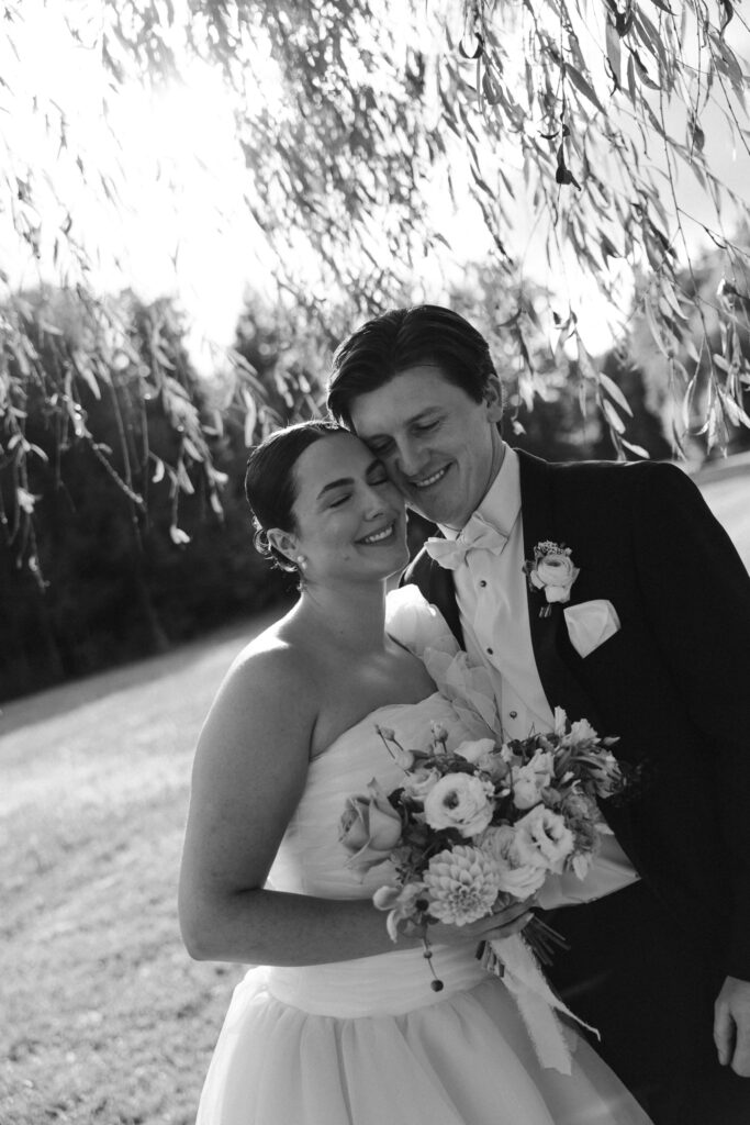 bride and groom embrace during emotional just married photos under the willow tree