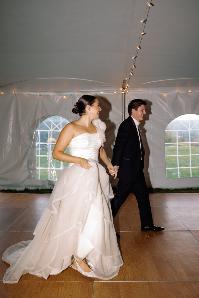 bride and groom enter tent for first dance