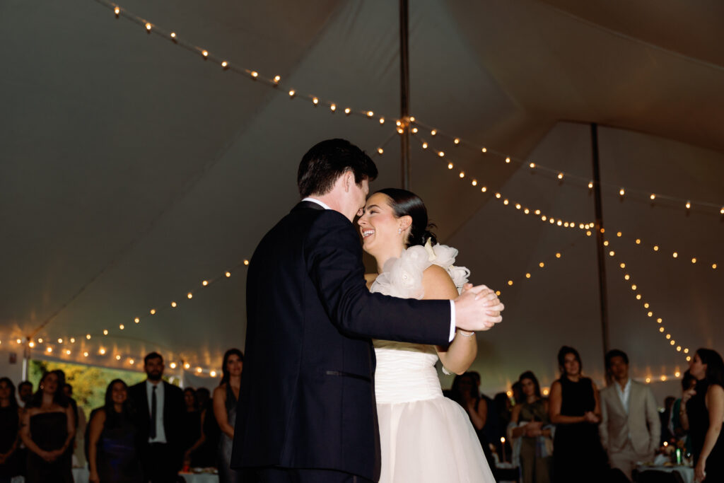 bride and groom dance under string lights