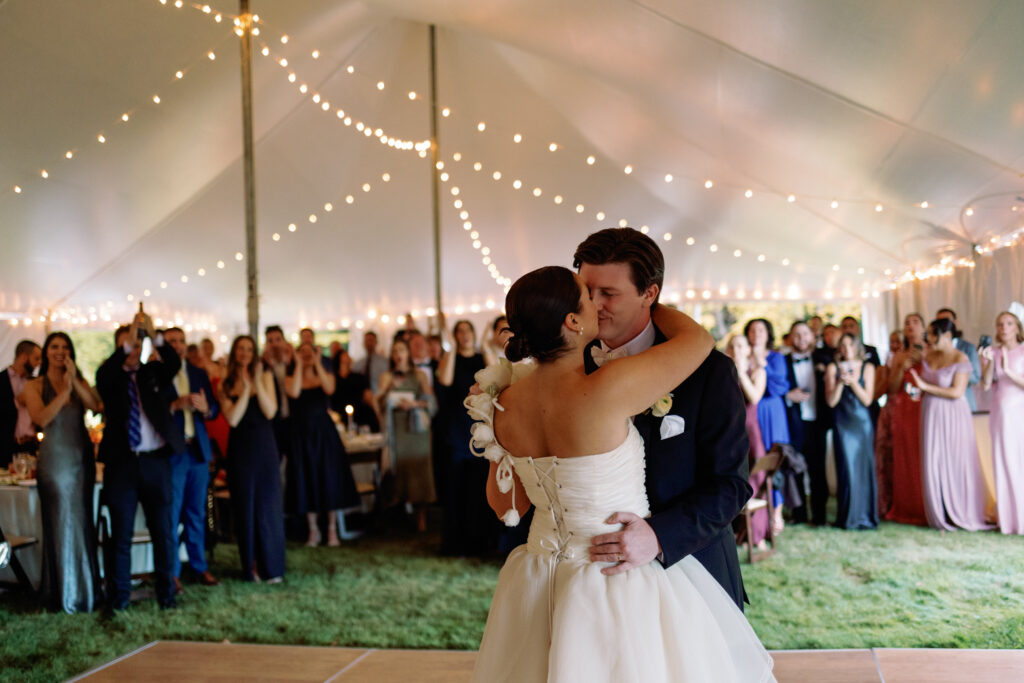 bride and groom emotional first dance and kiss while guests cheer
