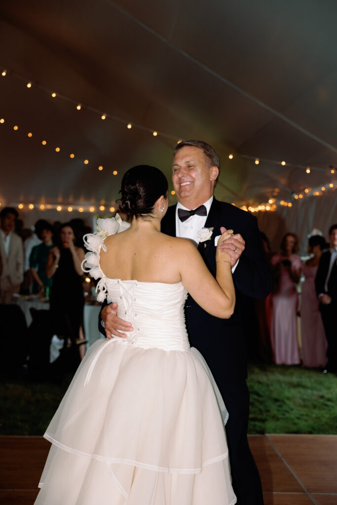 bride dances with her dad during tented wedding reception at backyard wedding