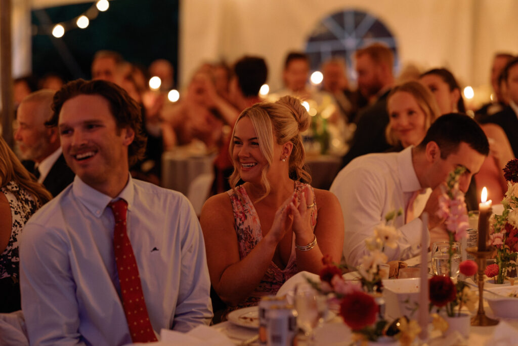 guests are lit with candlelight and clap during toasts