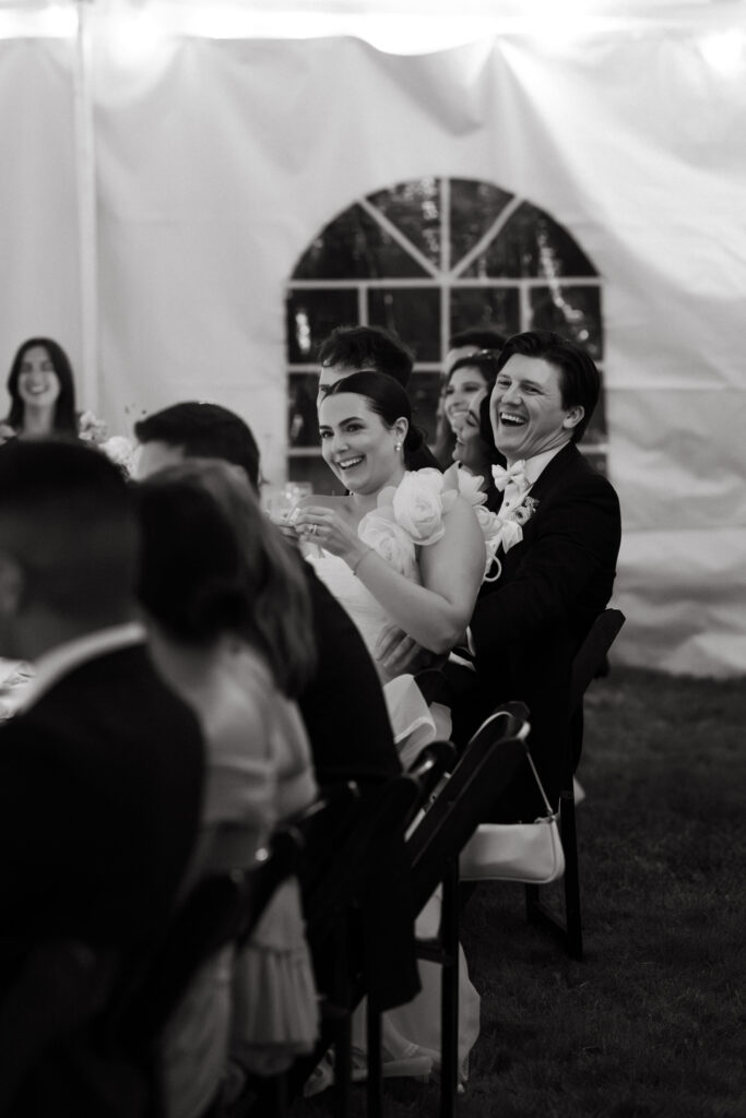 bride and groom laugh during toasts