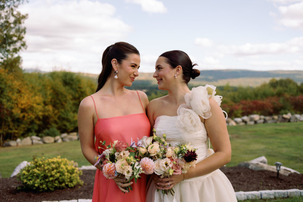 bride and bridesmaid smile at each other during portraits