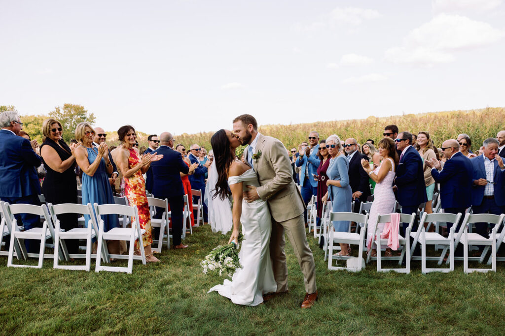 A groom kissing his bride after their backyard wedding ceremony. 