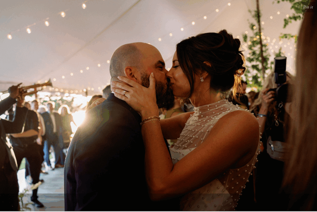 A bride and groom kiss at their reception party.