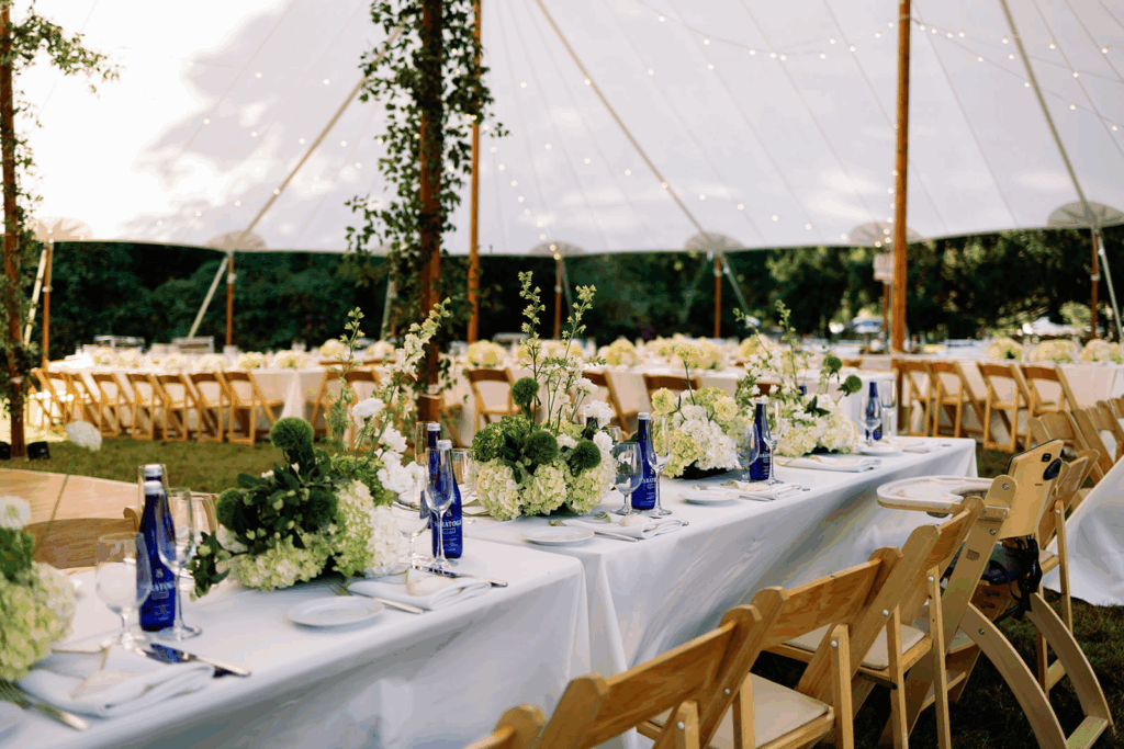 Reception tables with coastal wedding decor, hydrangeas, and saratoga bottles.