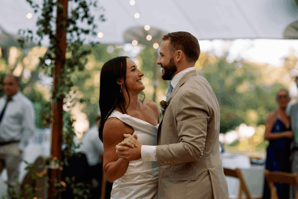 A bride and groom slow dance together at their outdoor wedding reception.