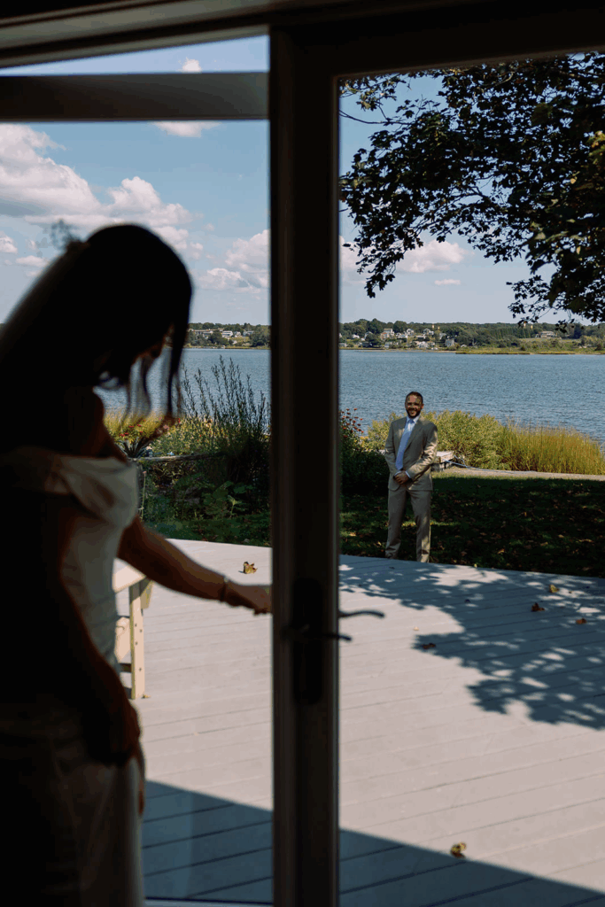A groom watching his bride walk out for their first look.