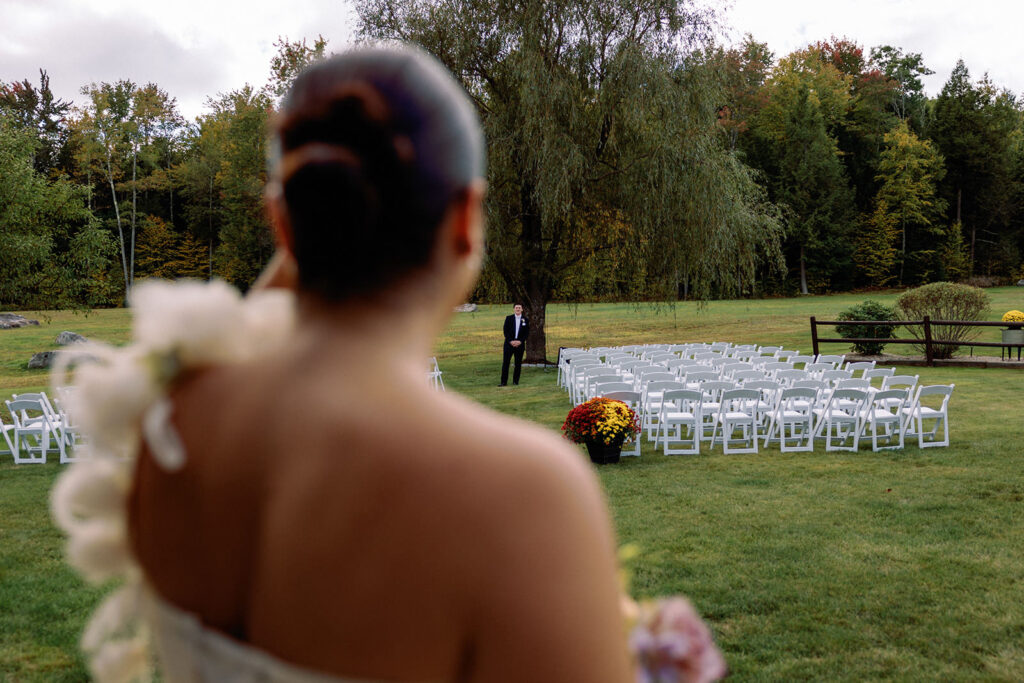 Backyard wedding with a bride looking out across the yard at the groom.