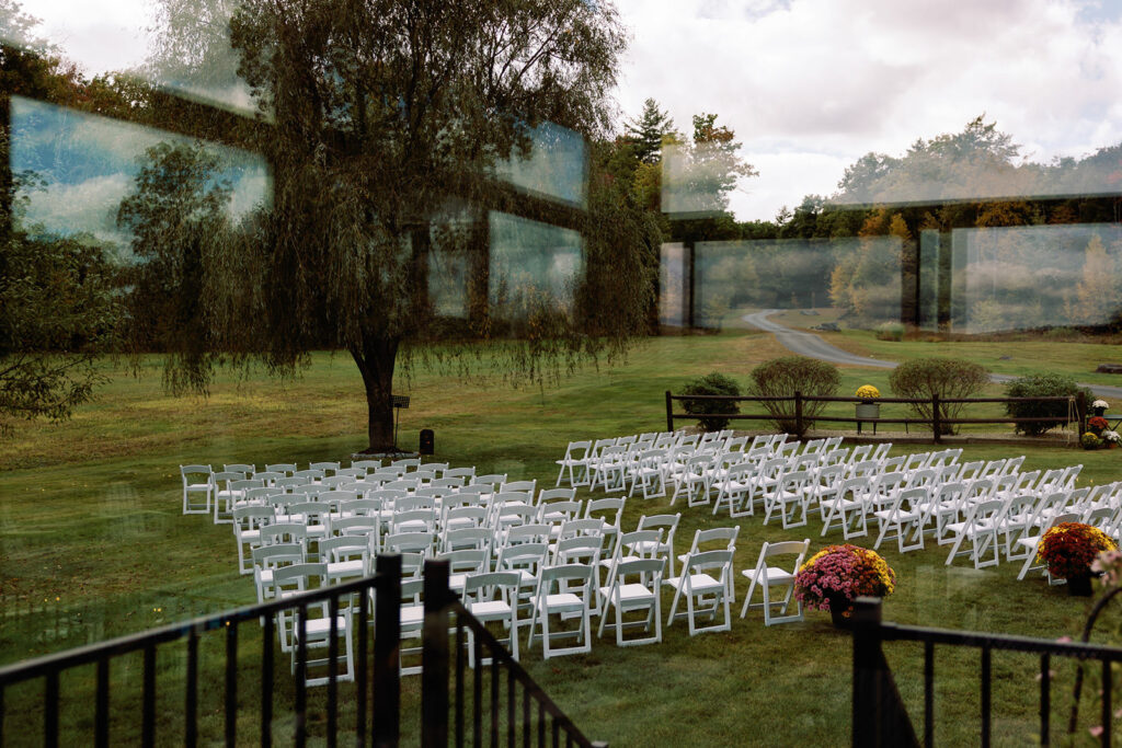 View of a backyard wedding ceremony set up through a window before the ceremony takes place. 