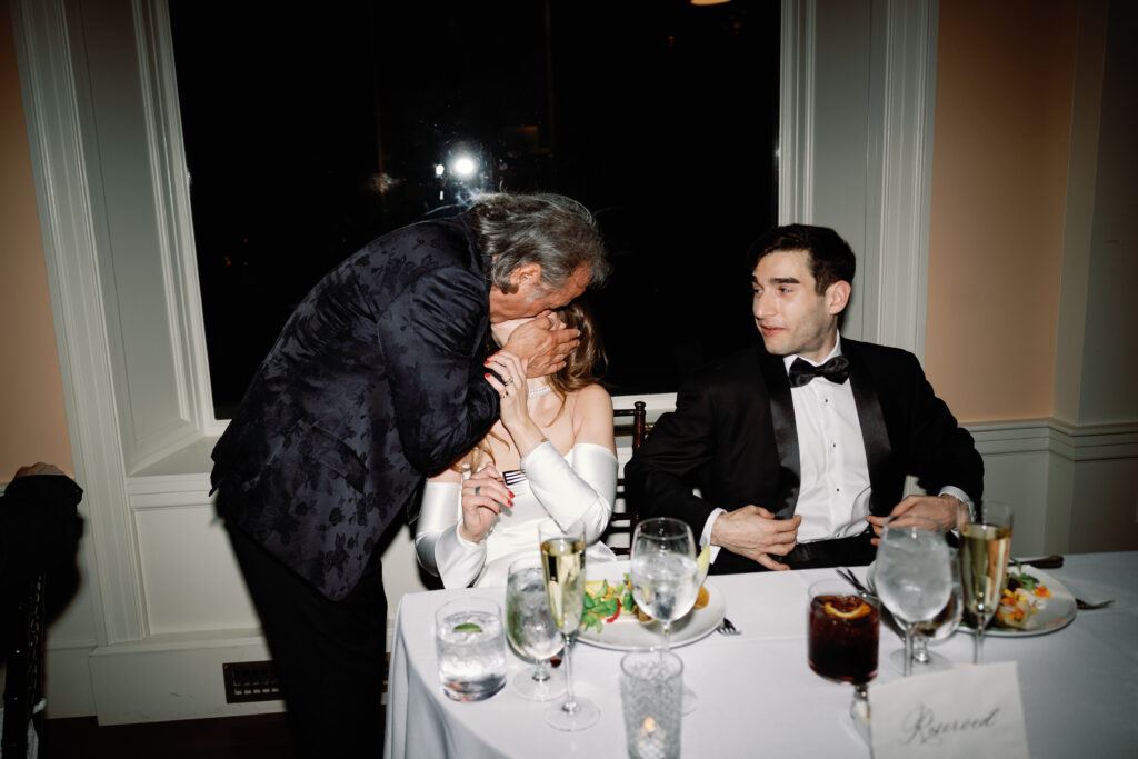 father of bride kisses bride after toast in documentary wedding photo 