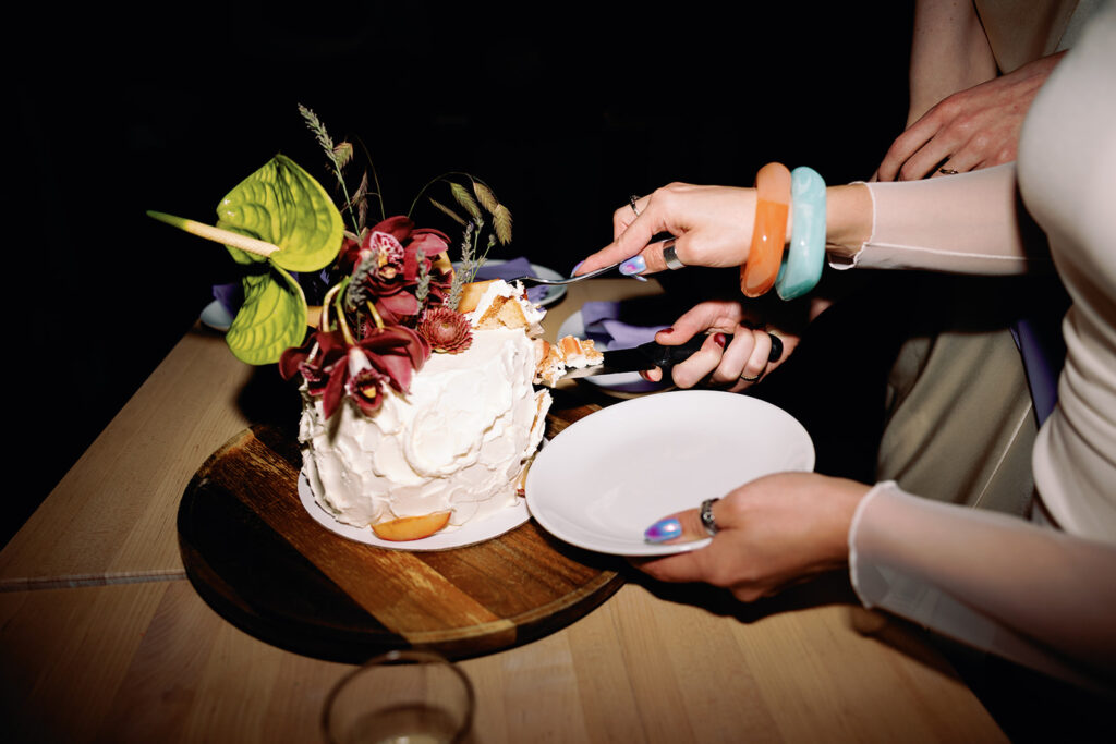 funky and colorful wedding cake being cut