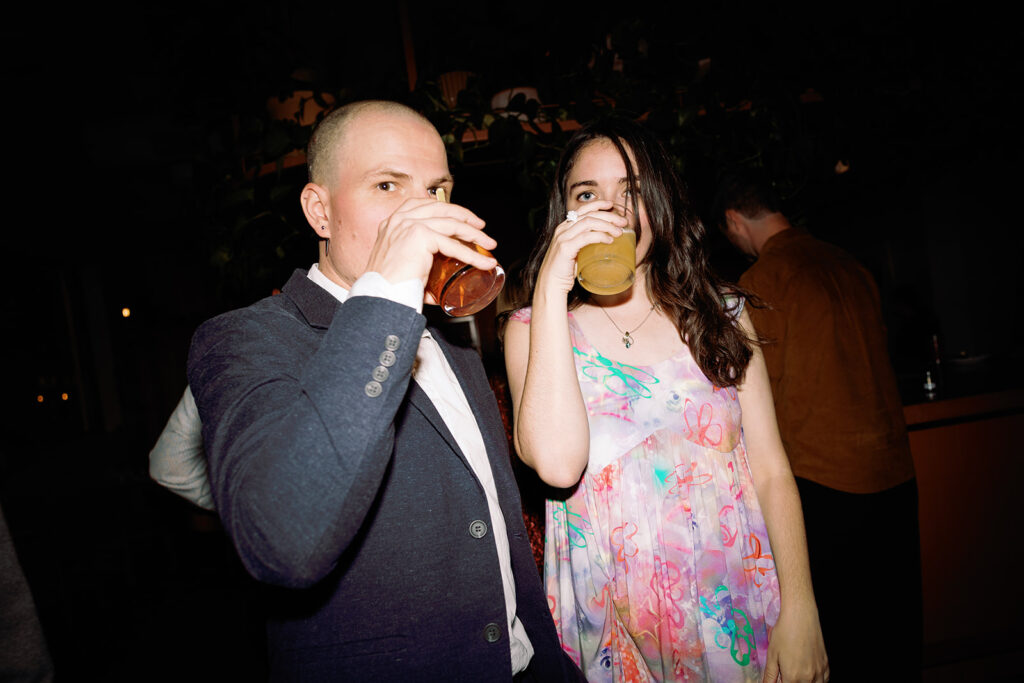 guests toast during cocktail hour in candid late night wedding photo