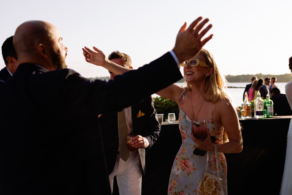 guests hug during cocktail hour at Mount Hope Farm September wedding 