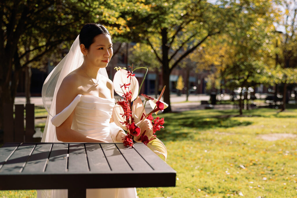 bride smiles while the sun hits her veil in candid photograph in Central Square city wedding